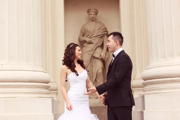Bride and groom near white columns — Stock Photo, Image