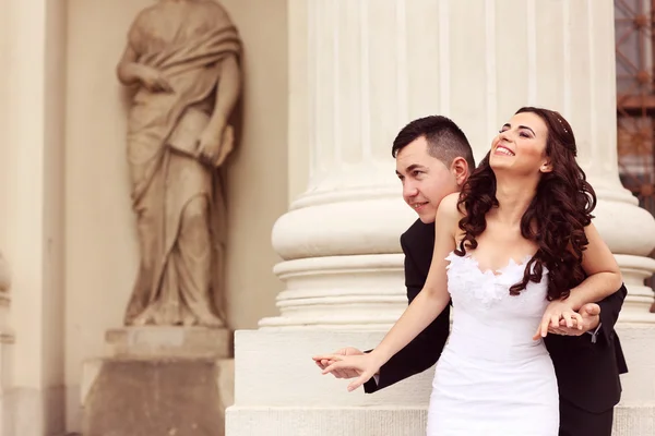 Bride and groom near white columns — Stock Photo, Image