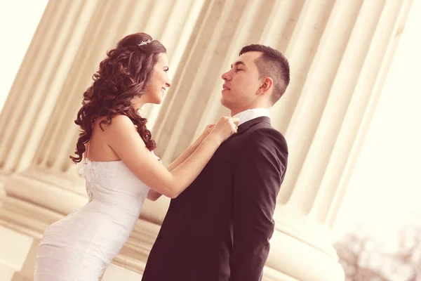 Bruden och brudgummen nära kolumner — Stockfoto