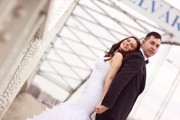 Novia y novio en un puente — Foto de Stock