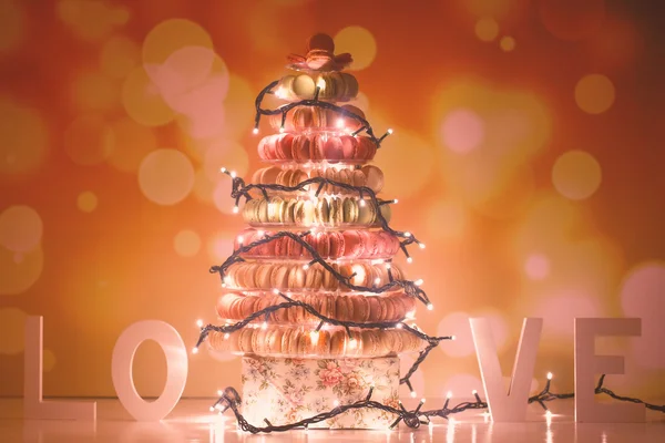 Pyramid of macaroons and Christmas lights — Stock Photo, Image