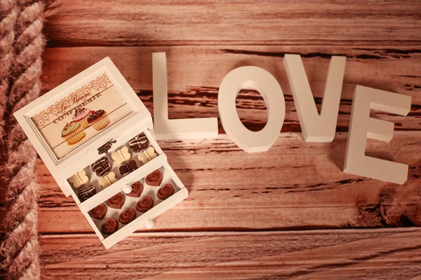 Mini chocolate sweets and LOVE letters — Stock Photo, Image