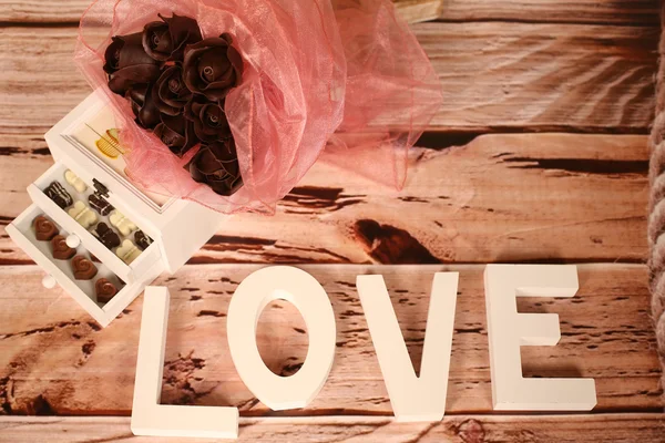 Mini bonbons au chocolat et lettres d'AMOUR sur la table — Photo