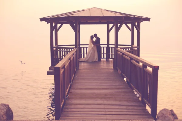 Braut und Bräutigam auf Holzbrücke — Stockfoto