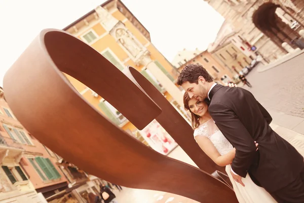 Жених и невеста возле скульптуры в форме сердца — стоковое фото