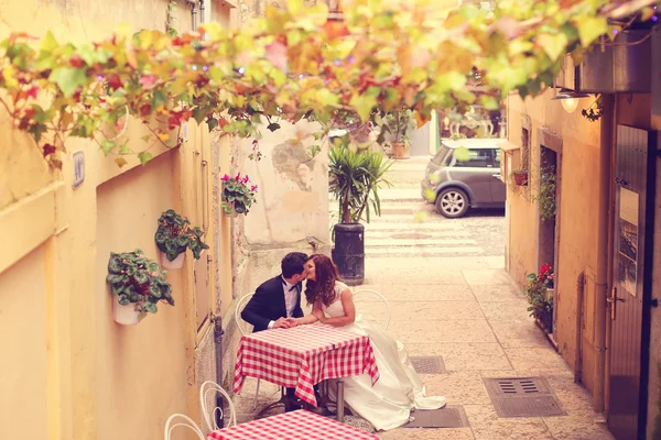 Bride and groom sitting on table — Stock Photo, Image