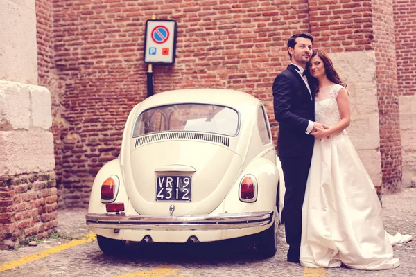 Bruden och brudgummen nära vintage bil — Stockfoto
