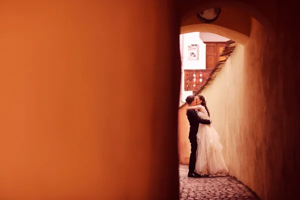 Bride and groom on a narrow street — Stock Photo, Image