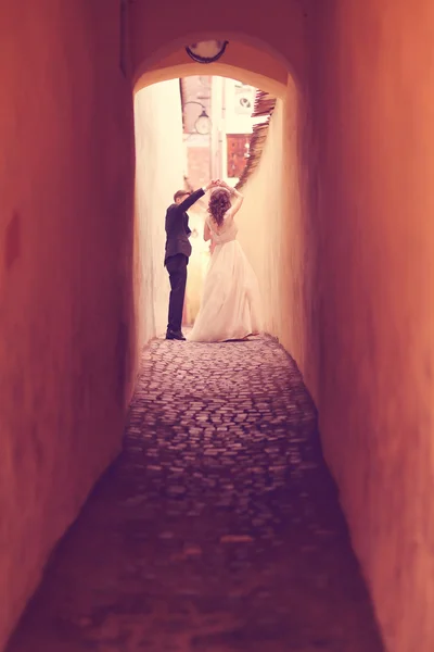 Bride and groom on a narrow street — Stock Photo, Image