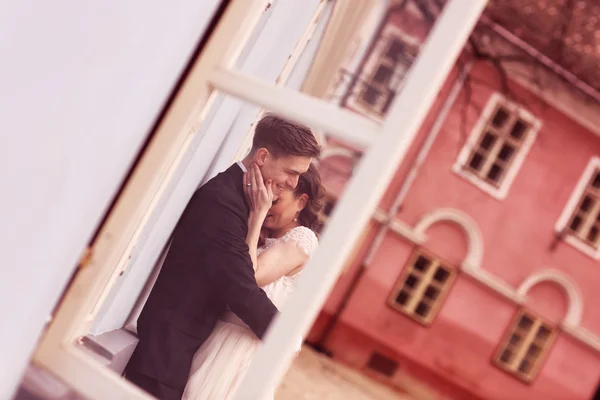 Bruden och brudgummen embracing i staden — Stockfoto