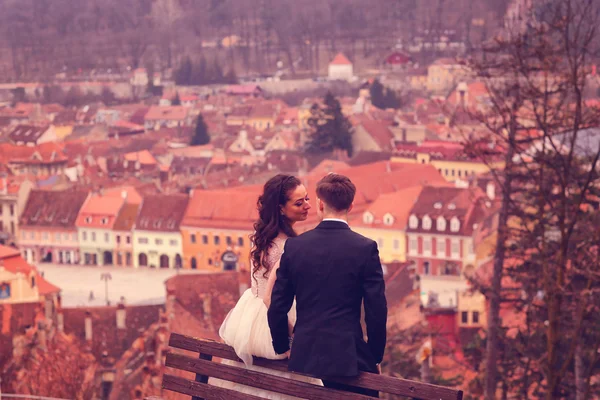 Bride and groom sitting on a bench in the city — Stock Photo, Image