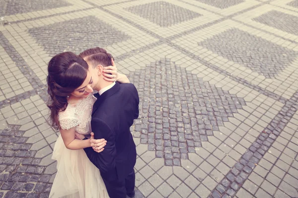 Mariée et marié embrassant sur la rue pavée — Photo