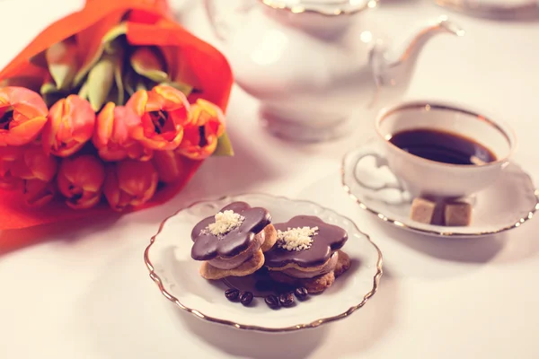 Leckerer Kuchen mit Kaffee und Tulpen auf dem Tisch — Stockfoto
