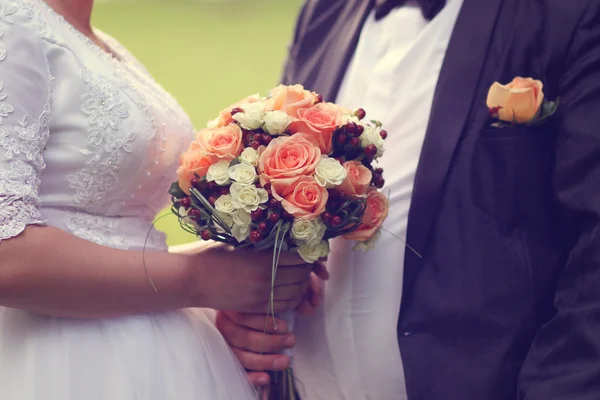 Νύφη κρατώντας την γαμήλια ανθοδέσμη από τριαντάφυλλα — Φωτογραφία Αρχείου