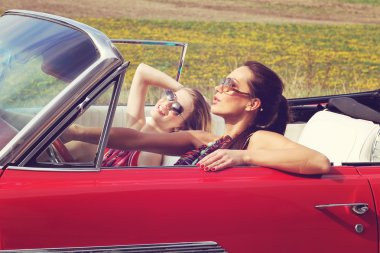 Eski model bir retro Araba sürme güneş gözlüğü ile güzel bayanlar