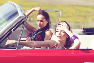 Eski model bir retro Araba sürme güneş gözlüğü ile güzel bayanlar