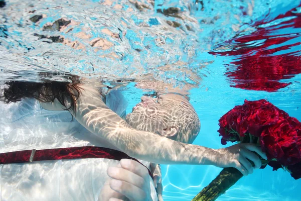 Nevěsta a ženich líbat pod vodou — Stock fotografie