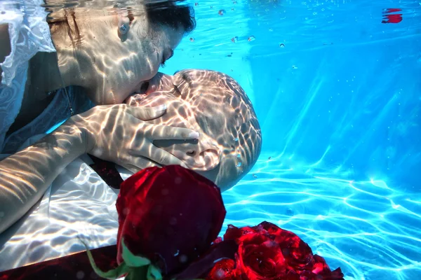 Nevěsta a ženich líbat pod vodou — Stock fotografie