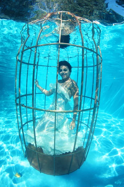 Fantasy bride underwater in a bird cage — Stock Photo, Image