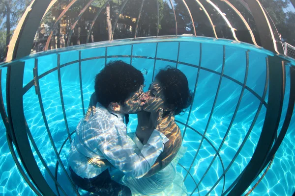 Romantic bride and groom underwater in a bird cage — Stock Photo, Image