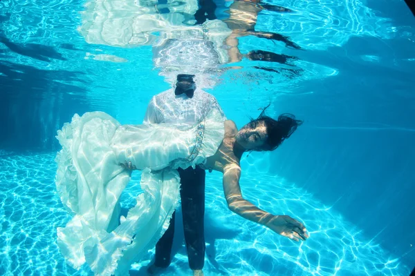 Ženich drží svou nevěstu pod vodou — Stock fotografie