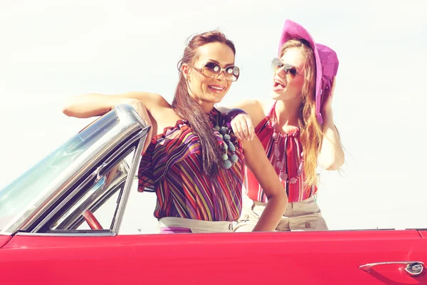 Belles dames avec des lunettes de soleil posant dans une voiture rétro vintage — Photo