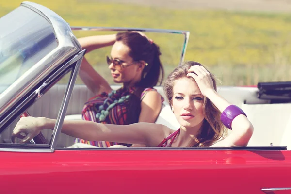 Hermosas damas con gafas de sol montando un coche retro vintage —  Fotos de Stock