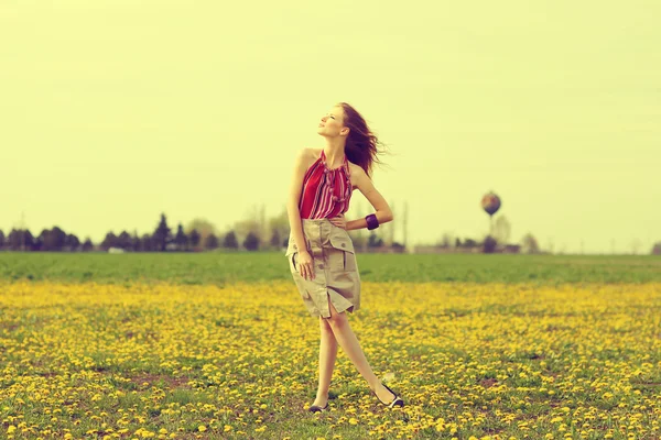 Beautiful young girl in a field of flowers — Stock Photo, Image