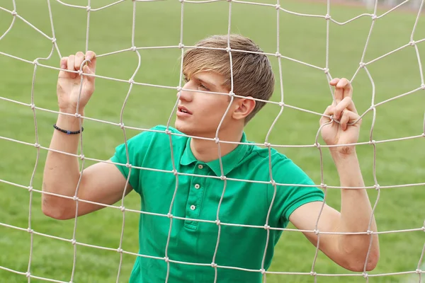 Young man looking through net soccer football goal catch — Stock Photo, Image