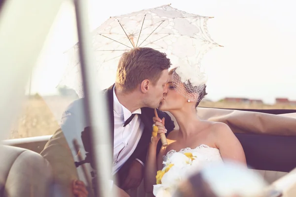 Bride and groom in a vintage car — Stock Photo, Image