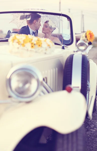 Novia y novio en un coche vintage — Foto de Stock