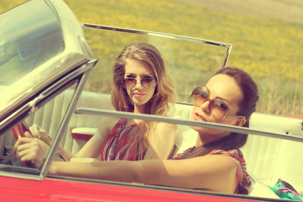 Красивые женщины водят красную машину ретро-винтажную носить accesoriess — стоковое фото