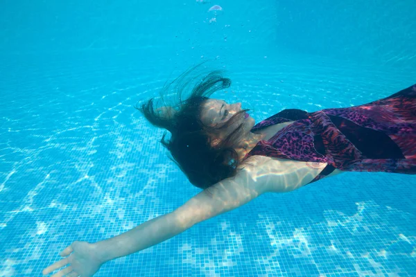 Mujer bajo el agua nadando con su vestido puesto — Foto de Stock