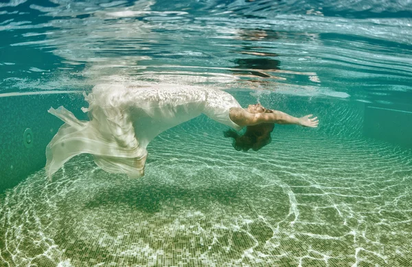 Frau schwimmt unter Wasser und trägt ihr Brautkleid — Stockfoto