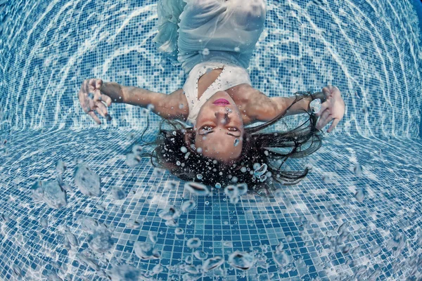 Woman underwater swimming wearing her wedding dress — Stock Photo, Image