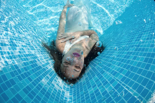 Woman underwater swimming wearing her wedding dress — Stock Photo, Image