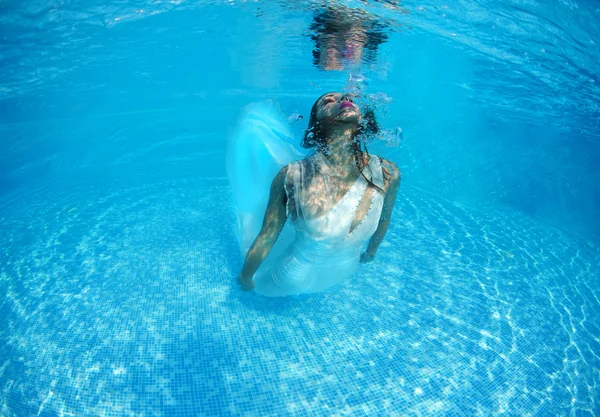 Woman underwater swimming wearing her wedding dress — Stock Photo, Image