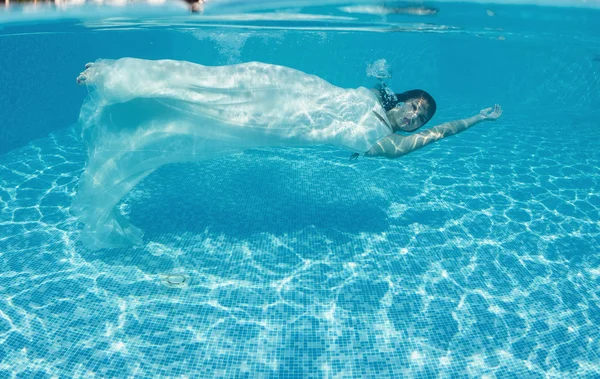 Mujer bajo el agua nadando usando su vestido de novia — Foto de Stock