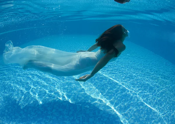 Mujer bajo el agua nadando usando su vestido de novia —  Fotos de Stock