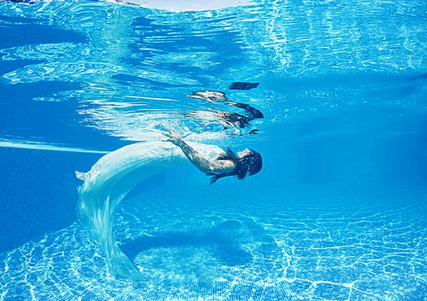 Mujer bajo el agua nadando usando su vestido de novia —  Fotos de Stock