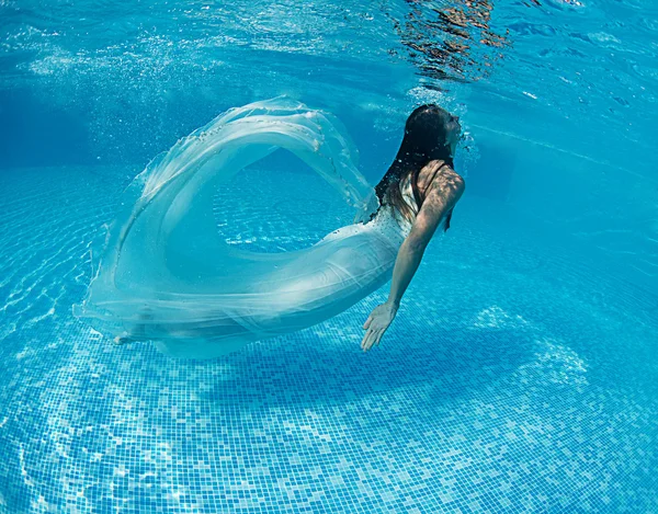 Женщина под водой купается в свадебном платье — стоковое фото