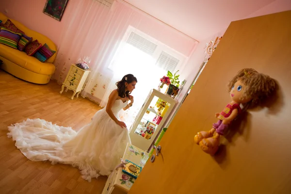 Невеста смотрит в зеркало и готовится к свадьбе. — стоковое фото