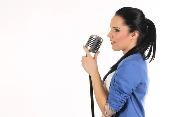 Retrato de uma menina glamourosa segurando um microfone e cantando — Fotografia de Stock