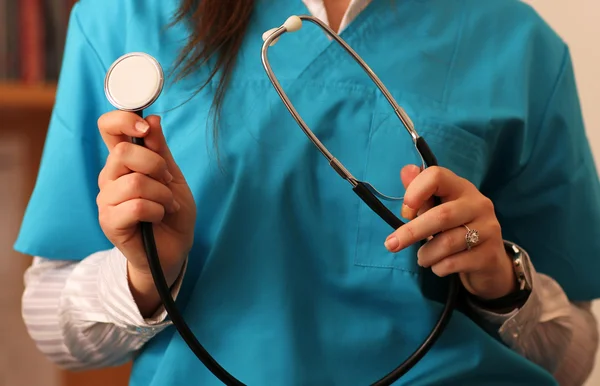Kvinnliga läkare håller ett stetoskop i hennes händer — Stockfoto