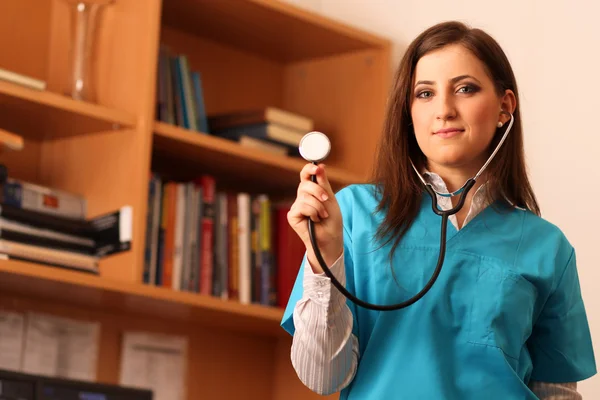 Kvinnliga läkare leende med stetoskop i händer — Stockfoto