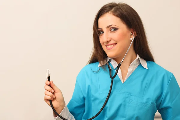 Medico femminile sorridente con stetoscopio in mano — Foto Stock