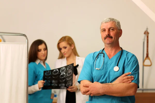 Лікар з двома медсестрами перевіряє радіографію — стокове фото