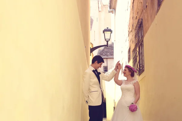 Bride and groom on a narrow street — Stock Photo, Image