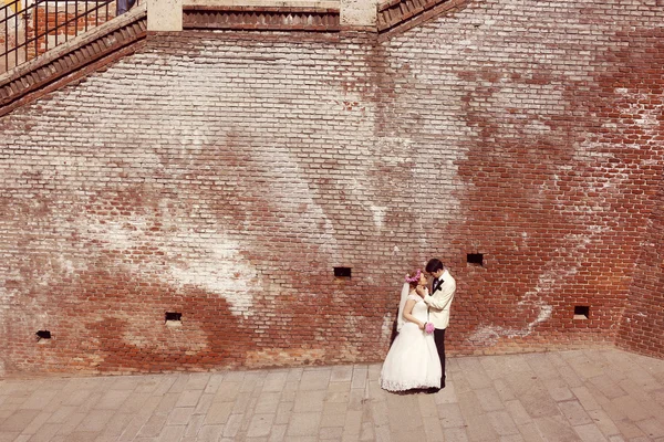 Bride and groom walking in old city — Stock Photo, Image