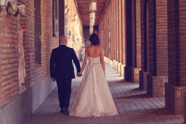 Gelin ve damat el ele tutuşuyorlar.